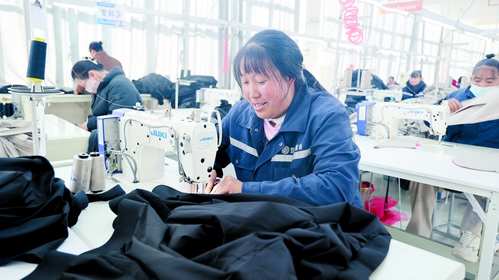 云南永昌服饰有限公司员工李松文（右）正在缝制衣服。和倩 摄